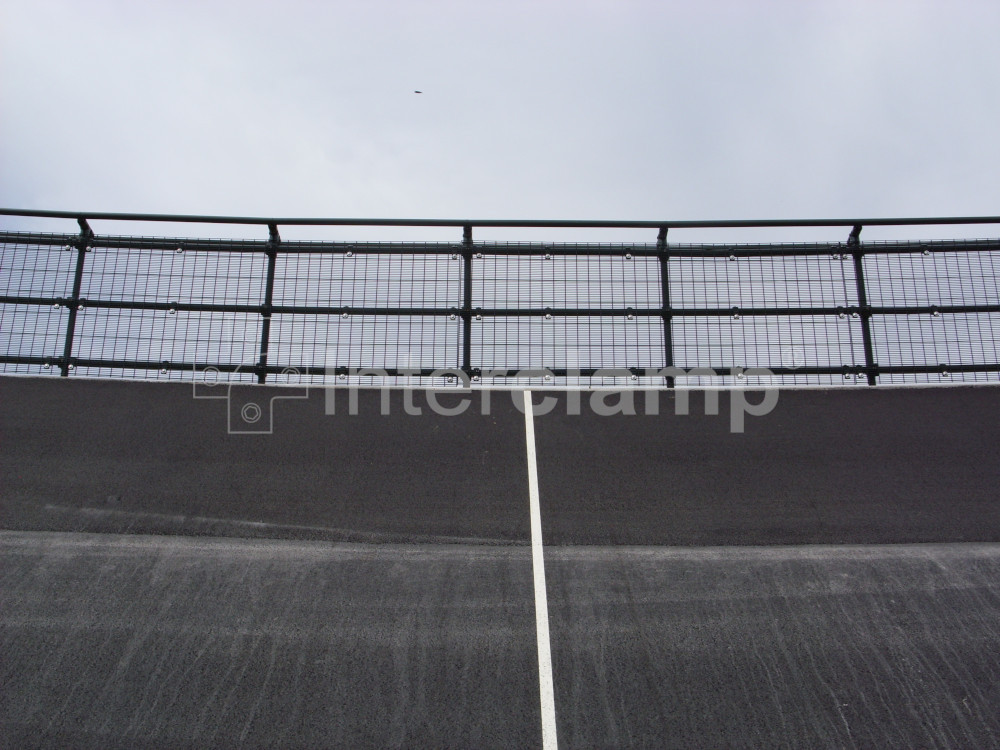 Interclamp tube clamp DDA fittings, powder-coated dark green, used to construct a protective barrier around a velodrome, enhancing both safety and aesthetics.